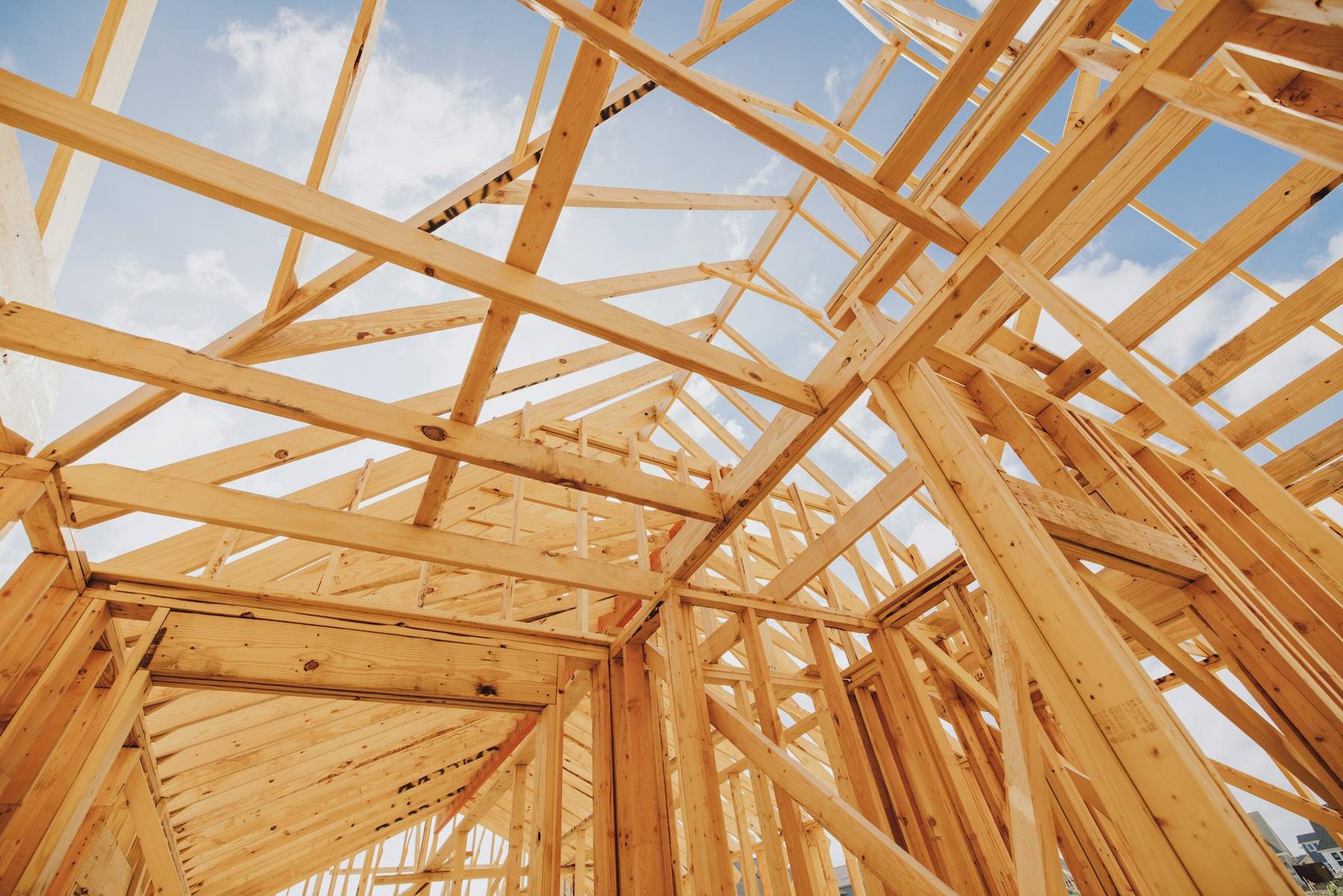 Dachstuhl aus hellem Holz vor blauem Himmel