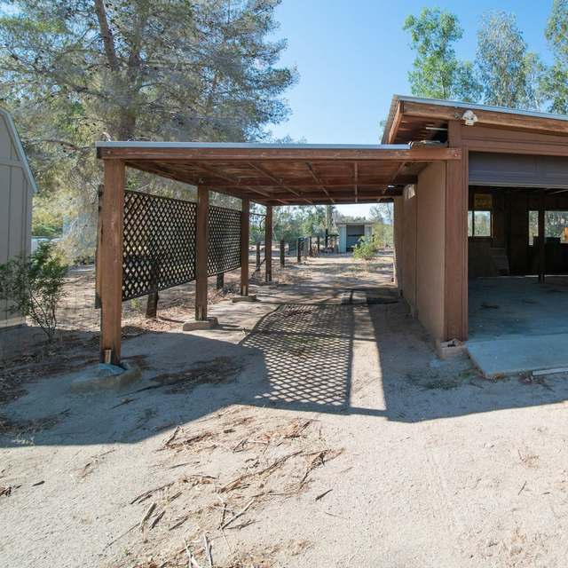 Leerer Carport aus Holz an einer Garage